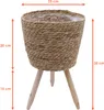 A woven planter on wooden legs with size indicators. Produktbild-Vorschau