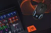A gaming keyboard and mouse are shown on a black mousepad with an orange abstract design. Anteprima dell’immagine prodotto