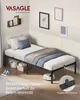 A bedroom scene featuring a single bed with bedding, a wall shelf with books, and framed pictures on the wall. Produktbild-Vorschau