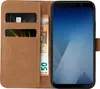 A brown leather flip case for a smartphone, with a credit card and banknotes inserted. Produktbild-Vorschau