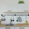 A clean and organized kitchen counter with a sink, cabinets, and kitchen utensils hanging on a rack. Produktbild-Vorschau
