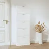 A white shoe cabinet with five drawers stands next to a white door, with a vase of dried wheat stalks on the right. Produktbild-Vorschau