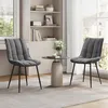 Two dark gray upholstered chairs are placed around a small round table in a bright room with a large window and a bookshelf in the background. Produktbild-Vorschau