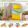 A stack of colorful foam blocks and a rainbow toy are shown in a room with a window and a couch. Below are examples of different layout options for the blocks. Produktbild-Vorschau