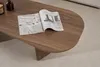 A wooden coffee table with an open magazine on it, placed on a carpeted floor. Produktbild-Vorschau
