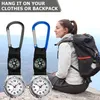A woman wearing a backpack and sitting on a rock, with two carabiner watches in the foreground. Produktbild-Vorschau