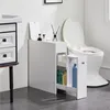 A slim white bathroom cabinet is shown next to a toilet, with various bathroom products inside. Produktbild-Vorschau