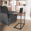 A laptop is placed on a C-shaped side table next to a gray armchair, with bookshelves in the background. Produktbild-Vorschau