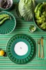 A table setting with plates, cutlery, and fresh vegetables. Produktbild-Vorschau