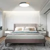 A modern bedroom with a bed, nightstands, and a ceiling light. Voir les images du produit