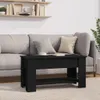 A black coffee table is placed in front of a sofa in a living room setting. Voir les images du produit