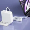A white laptop charger is plugged into a wall socket and connected to a laptop. Produktbild-Vorschau