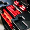 A close-up view of red and black plastic components within a storage system. Produktbild-Vorschau
