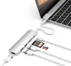 A silver USB-C hub is connected to a laptop and has multiple cables and SD cards plugged into it. Voir les images du produit