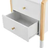 A close-up view of a white nightstand with wooden accents, showing two drawers, one of which is open. Produktbild-Vorschau