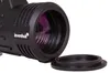 A close-up view of the objective lens of a monocular, with its protective cap removed and placed nearby. Produktbild-Vorschau