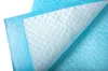 A close-up, angled view of a disposable training pad, showing its quilted texture and some water droplets on the blue backing. Produktbild-Vorschau