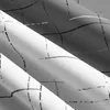 A close-up view of folded fabric with a grid pattern. Produktbild-Vorschau