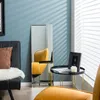 A living room scene with a mirror, chair, and side table. Produktbild-Vorschau