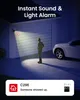A security camera illuminates a person standing in front of a garage door at night, with a car parked nearby. A notification bubble is shown at the bottom. Produktbild-Vorschau