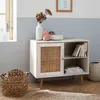 A light-colored sideboard with a rattan door is placed in a room with a window and a basket. Anteprima dell’immagine prodotto