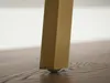 A close-up shot of the bottom of a table leg with a small roller on a wooden floor. Voir les images du produit