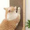 A cat is scratching a cardboard scratching post attached to a wall. Voir les images du produit