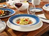 A table setting with plates of food and wine. Náhľad obrázku produktu