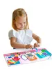 A young girl playing with a magnetic dress-up doll. Produktbild-Vorschau