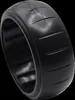 A close-up, angled view of a black tire with tread marks, isolated on a black background. Produktbild-Vorschau