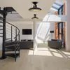 Interior view of a modern loft-style living space with a spiral staircase, seating area, and exposed brick. Produktbild-Vorschau