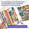A hand is holding a magnetic train piece near an open magnetic play box with train-themed magnetic pieces. Produktbild-Vorschau