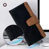 A black and brown leather wallet case for a phone is shown at an angle, with a close-up inset of the texture. The background is a blurred office or desk setting. Produktbild-Vorschau