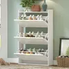 A white shoe cabinet with multiple flip-down drawers filled with shoes, placed in a room with a light green wall and a window. Náhled obrázku produktu