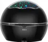 A black star projector lamp with colorful stars projected on its dome. Voir les images du produit