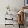 A small black side table with a glass top sits next to a brown sofa with a beige throw blanket draped over it. Anteprima dell’immagine prodotto
