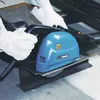 A person wearing white gloves is using a blue and black Makita metal circular saw to cut a piece of metal. Náhľad obrázku produktu