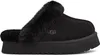 A black Ugg slipper with a fluffy trim is shown from the side against a white background. Anteprima dell’immagine prodotto
