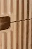 A close-up view of the textured wooden surface of a cabinet or furniture piece, showing the vertical grooves and a slight gap between two sections. Náhľad obrázku produktu