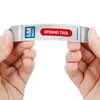 Hands holding a white opening tool with a blue and red logo and text. Produktbild-Vorschau