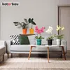 A living room scene with a sofa, coffee table, and several potted plants. Voir les images du produit