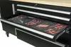 A close-up view of an open drawer in a black workbench, filled with tools organized in foam cutouts. Produktbild-Vorschau