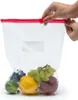 A hand is closing a resealable plastic bag filled with fruits. Anteprima dell’immagine prodotto
