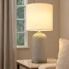 A table lamp is placed on a side table next to a window with curtains. Anteprima dell’immagine prodotto