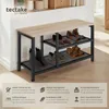A shoe rack with shoes on it, placed indoors near a wall and a shelf with decorative items. Náhled obrázku produktu