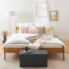 A bedroom scene with a bed, pillows, blankets, a floor lamp, and a storage bench in the foreground. Náhľad obrázku produktu