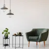 A living room scene with a plant stand, a side table with tea set, and an armchair. Podgląd zdjęcia produktu