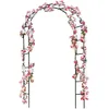 A black metal garden arch decorated with artificial pink and white flowers. Produktbild-Vorschau