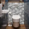 Graue Ziegelmuster-Tapete an einer Badezimmerwand hinter einer weißen Toilette und einem Waschbecken angebracht Náhled obrázku produktu
