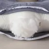 A close-up view of a pillow with its cover partially unzipped, revealing the white filling. Náhled obrázku produktu